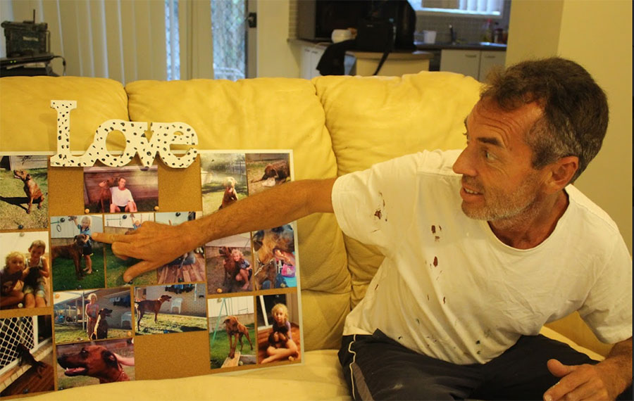 Michael shows off his photo board, covered in photos of his teenagers as toddlers