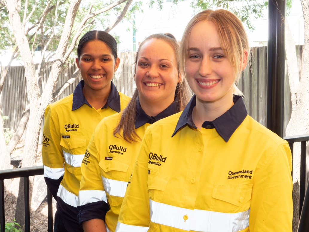 Three smiling young women in hi-vis work clothing
